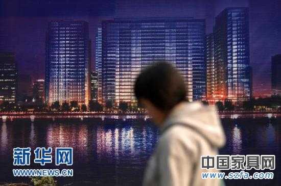 一位市民從杭州市區(qū)的一處商業(yè)樓盤廣告牌前走過（2010年11月4日攝）。新華社記者 黃宗治 攝 